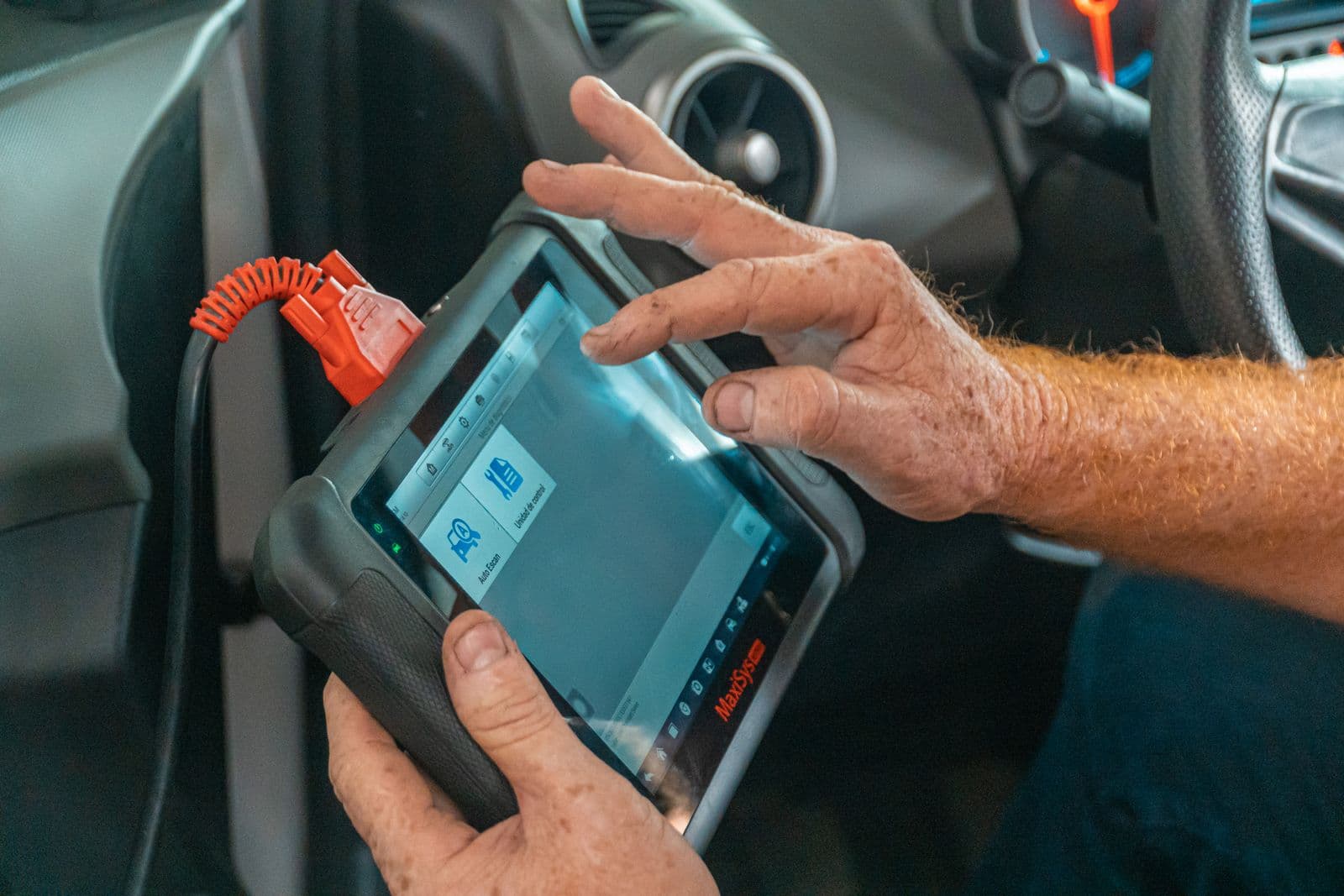 Diagnostic scan tablet plugged into a car, reading live engine data